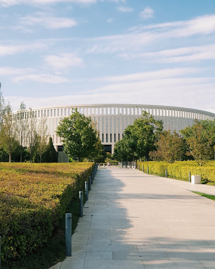 Modern architectural structure with lush green gardens and a clear sky, perfect for travel and architecture themes.